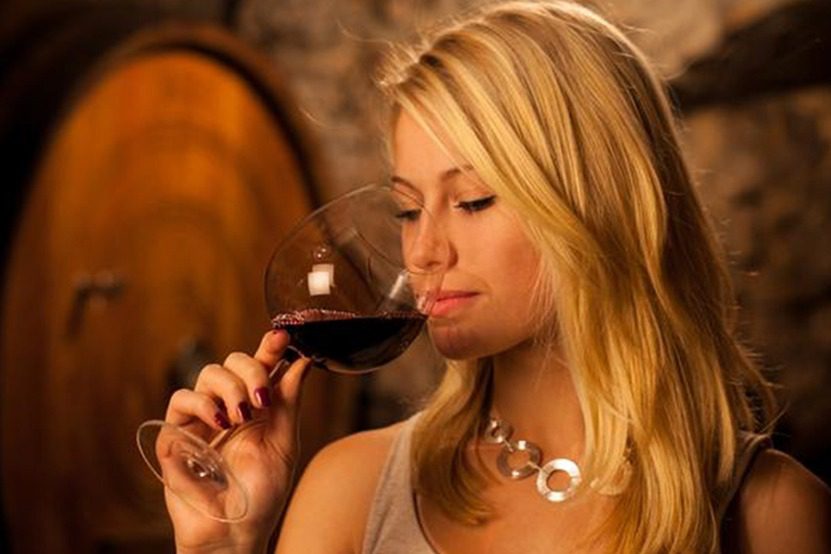 Woman about to drink a glass of red wine on a wine tour from Cheers Okanagan tours